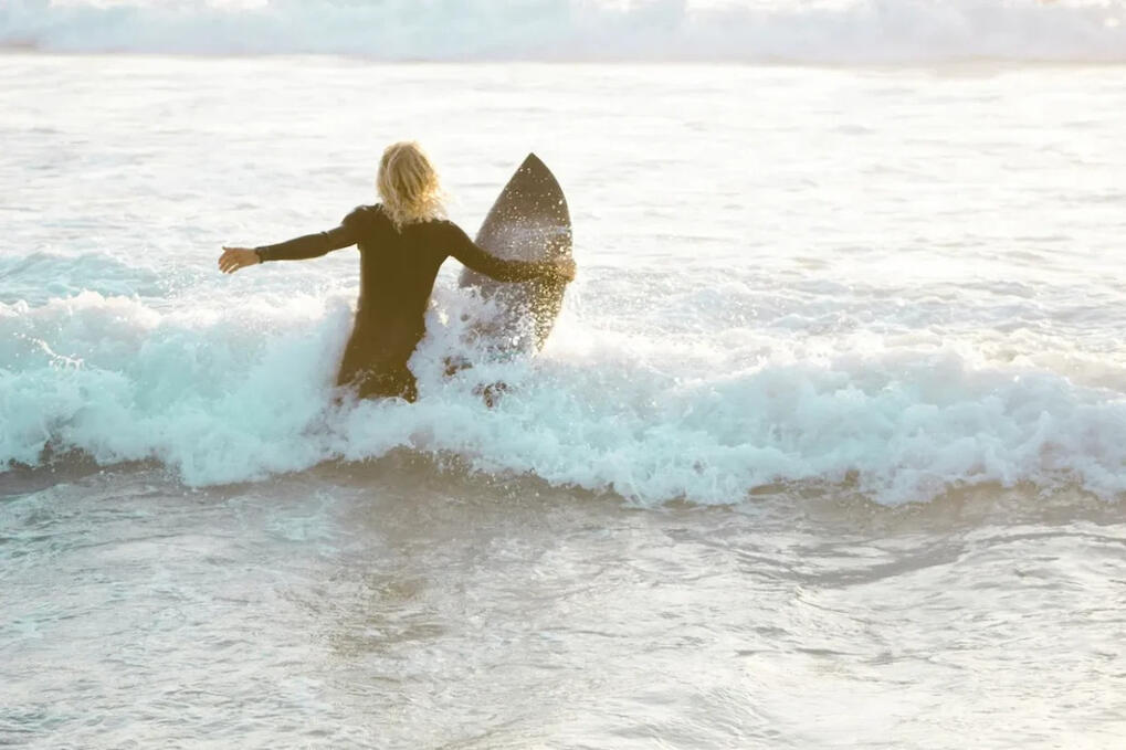 surfer jumping in waves with his surfboard